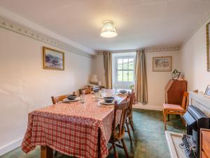een eetkamer met een tafel en stoelen bij Haweswater Cottage in Bampton