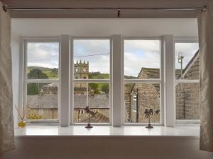 a window with three views of a church at Weavers Houses - Uk12796 in Hayfield