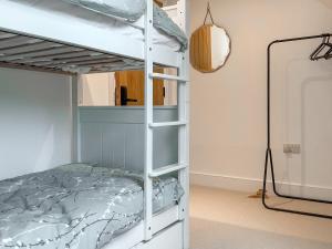 a bunk bed in a room with a bed in a room at Walnut Cottage Barn in Clevedon +10 photos