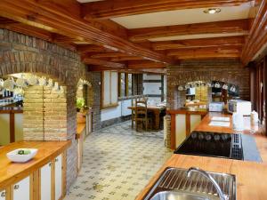 a large kitchen with wooden ceilings and a stone wall at The Farmhouse - Ukc1339 in North Molton +15 photos