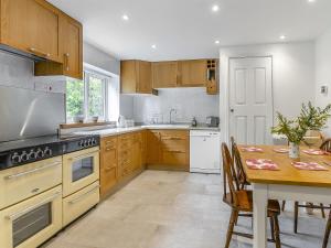 a kitchen with a table and a stove top oven at The Retreat in Pandy