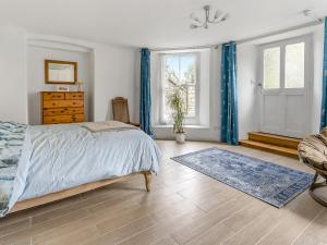 a bedroom with a bed and a chair and a dresser at The Retreat in Pandy