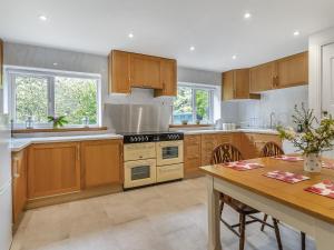 a large kitchen with wooden cabinets and a table at The Retreat in Pandy