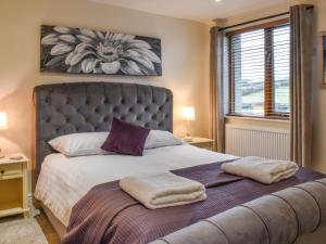 a bedroom with a large bed with two towels on it at Sailing By in Carnforth