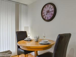 a table with chairs and a clock on the wall at Sailing By in Carnforth
