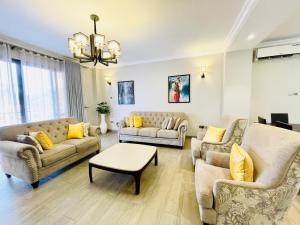a living room with two couches and a table at May Homes III in Kampala
