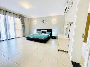 a bedroom with a bed and a large tile floor at May Homes III in Kampala