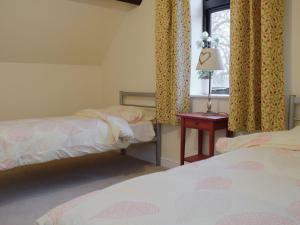 una camera da letto con due letti e una finestra di The Boyne Arms Cottage a Burwarton