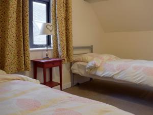 una camera da letto con due letti e un tavolo con una lampada di The Boyne Arms Cottage a Burwarton
