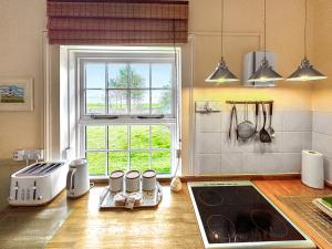 a kitchen with a stove and a window in it at Lighthouse Cottage in Happisburgh