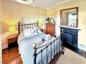 a bedroom with a bed with a fireplace and a mirror at Lighthouse Cottage in Happisburgh