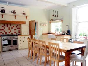 a kitchen with a wooden table and chairs at Abbott's Farm in Horbling