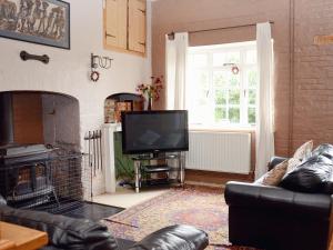 a living room with a couch and a television at Abbott's Farm in Horbling
