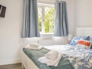 a bedroom with a bed with towels on it at Puffin Cottage in Amble