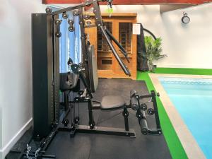 a gym with a chair next to a swimming pool at Puffin Cottage in Amble +5 photos