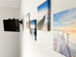 a tv hanging on a wall with pictures on it at Corner Farm - Uk41369 in Carnaby +11 photos