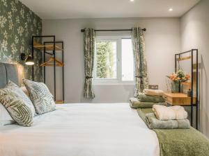a bedroom with a large white bed and a window at Swallow Lodge - Uk42540 in Winforton +8 photos