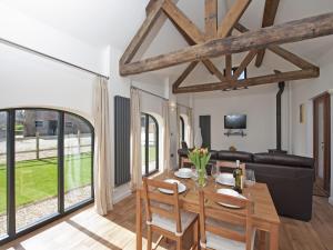 a dining room with a table and a couch at Oak Barn - Fernhill Farm in Wootton Bridge