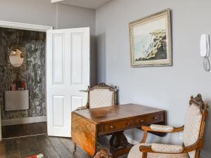 a room with a wooden desk and two chairs at Wellesley Retreat in Hastings