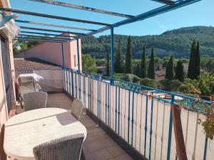 a patio with a table and chairs on a balcony at Digital Detox Relaxation and Games in Roquefort-la-Bédoule