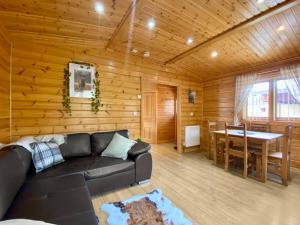 a living room with a black couch and a table at Magnolia Lodge-Uk46280 in Camerton