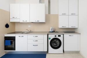 a kitchen with white cabinets and a washing machine at Casa cobalto vicinissima al centro by Turin House Collection in Turin
