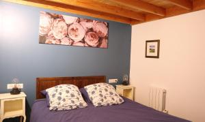 a bedroom with a bed with a painting on the wall at AN GOVEL in Crozon