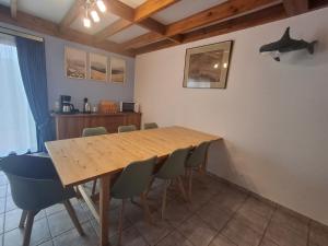 a dining room with a wooden table and chairs at De Zeebries in De Haan