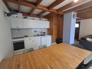 a kitchen with a wooden table and a table and chairs at De zeebries in De Haan +9 photos