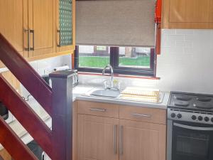 a kitchen with a sink and a stove and a window at Trevithick Lodge in Hayle
