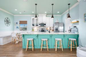 StingareeにあるSea Glass Retreat homeの青い島(バースツール付)のあるキッチン