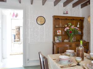 una sala da pranzo con un tavolo e un orologio a parete di Eastwood House a Brandesburton