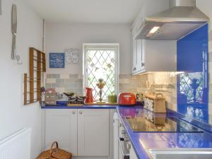 una cucina con ripiani blu e una finestra di Eastwood House a Brandesburton