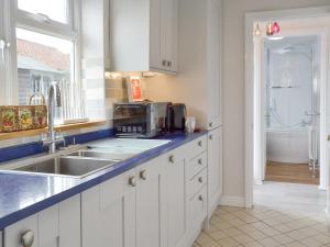 una cucina con mobili bianchi, un lavandino e una finestra di Eastwood House a Brandesburton Altre 10 foto
