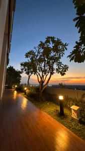 スラバヤにあるApartemen benson 21 pakuwon mall Luxury Studio Apartment Connecting Mall, Pool & City Viewの木々が見える木製の歩道
