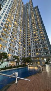 スラバヤにあるApartemen benson 21 pakuwon mall Luxury Studio Apartment Connecting Mall, Pool & City Viewの大きなアパートメントで、目の前にプールがあります。
