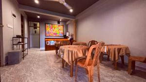 a dining room with tables and chairs and a painting on the wall at Raj Mahal Inn in Wadduwa