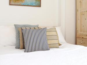 - un lit blanc avec des oreillers au-dessus dans l'établissement Half Turn Cottage, à Whitstable