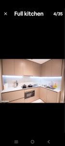 eine Küche mit weißen Schränken und einem Herd mit Backofen in der Unterkunft Eaton KL,2R1B,0 Service,KLCC,500mbps,2-4pax in Kuala Lumpur