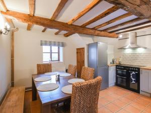 Una cocina con una mesa con sillas y un refrigerador. en Uk46590 - Longmynd, en Church Stretton