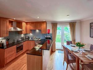 a large kitchen with wooden cabinets and a table at No4 The Links Apartments in Brora