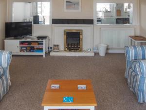 a living room with two couches and a fire place at Seagull Cottage in Pagham