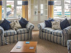 a living room with two couches and a coffee table at Seagull Cottage in Pagham