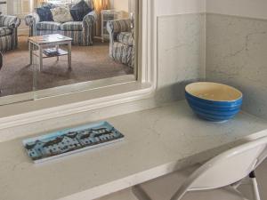 a bowl sitting on a counter in front of a mirror at Seagull Cottage in Pagham