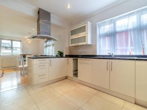 a kitchen with white cabinets and a stove top oven at The Great Escape in Ipswich +25 photos