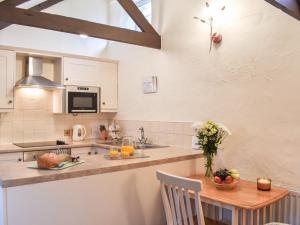 a kitchen with a table with fruits and vegetables on it at The Piggery - Uk49014 in Liskeard