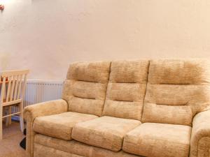 a brown couch sitting in a room with a chair at The Piggery - Uk49014 in Liskeard
