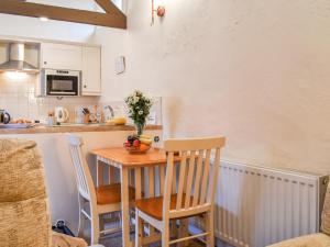 a kitchen with a small table with two chairs at The Piggery - Uk49014 in Liskeard