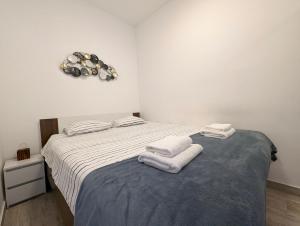 a bedroom with a bed with towels on it at Funktastic Central Maksimir Condo in Zagreb