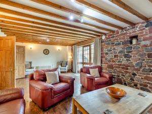 a living room with leather furniture and a brick wall at Barley Store - Uk48910 in Allonby